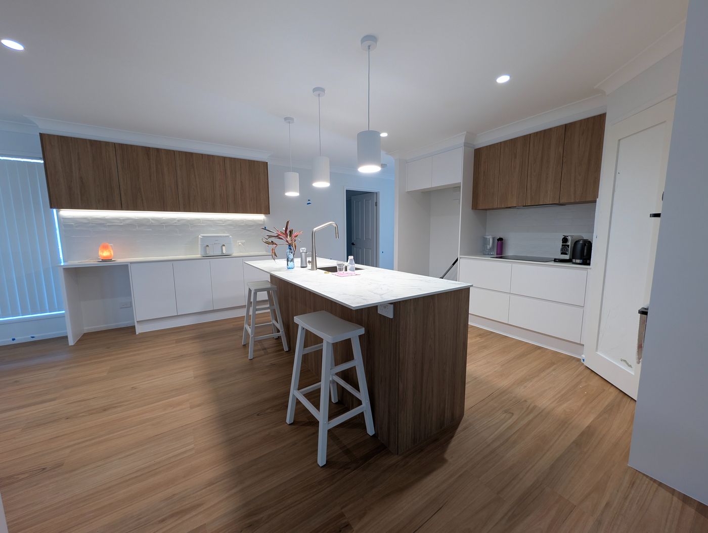 Kitchen renovation lighting with pendants over the island bench, LED downlights and under cabinet strip lighting, South East Queensland